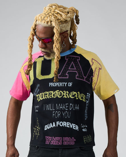 Person wearing a black t-shirt with colorful text and graphics on a gray background