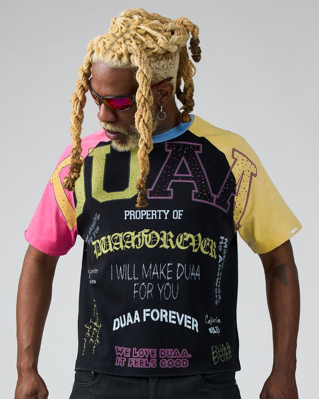 Person wearing a black t-shirt with colorful text and graphics on a gray background