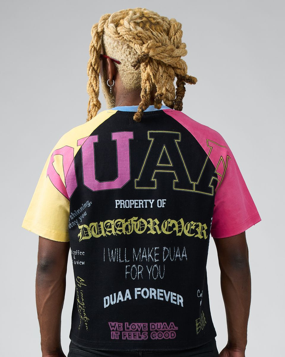 Person wearing a colorful t-shirt with text on the back against a gray background