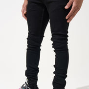 Person wearing black jeans and colorful sneakers on a white background