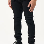 Person wearing black jeans and colorful sneakers on a white background