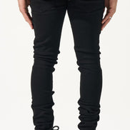 Person wearing black jeans and sneakers on a white background