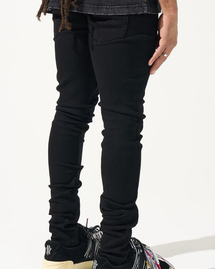 Person wearing black jeans and colorful sneakers on a white background