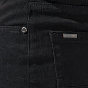 Close-up of black pants with a brand label on the pocket.
