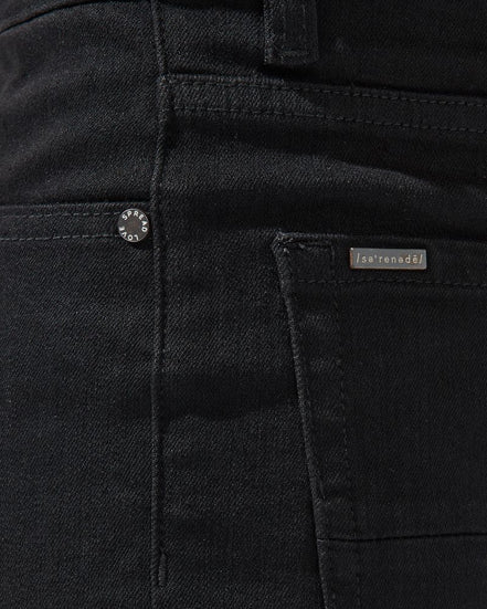 Close-up of black pants with a brand label on the pocket.