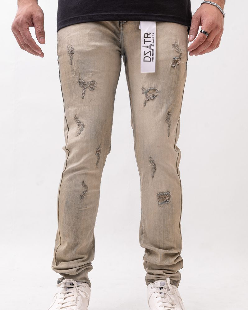 Beige distressed jeans worn by a person on a white background
