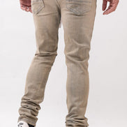 Person wearing beige jeans and white sneakers on a white background