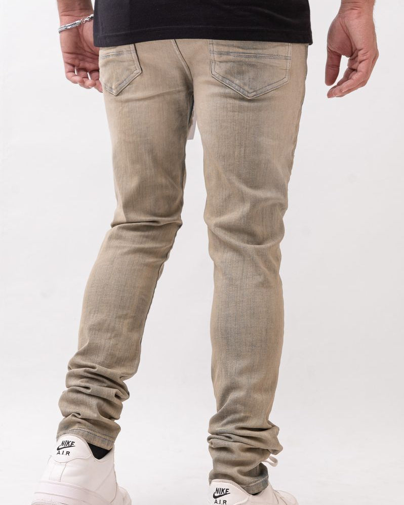 Person wearing beige jeans and white sneakers on a white background