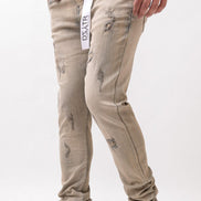 Beige distressed jeans worn by a person on a white background