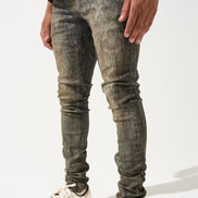 Person wearing distressed gray jeans and white Adidas sneakers on a white background