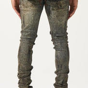 Person wearing distressed gray jeans and white sneakers on a plain background