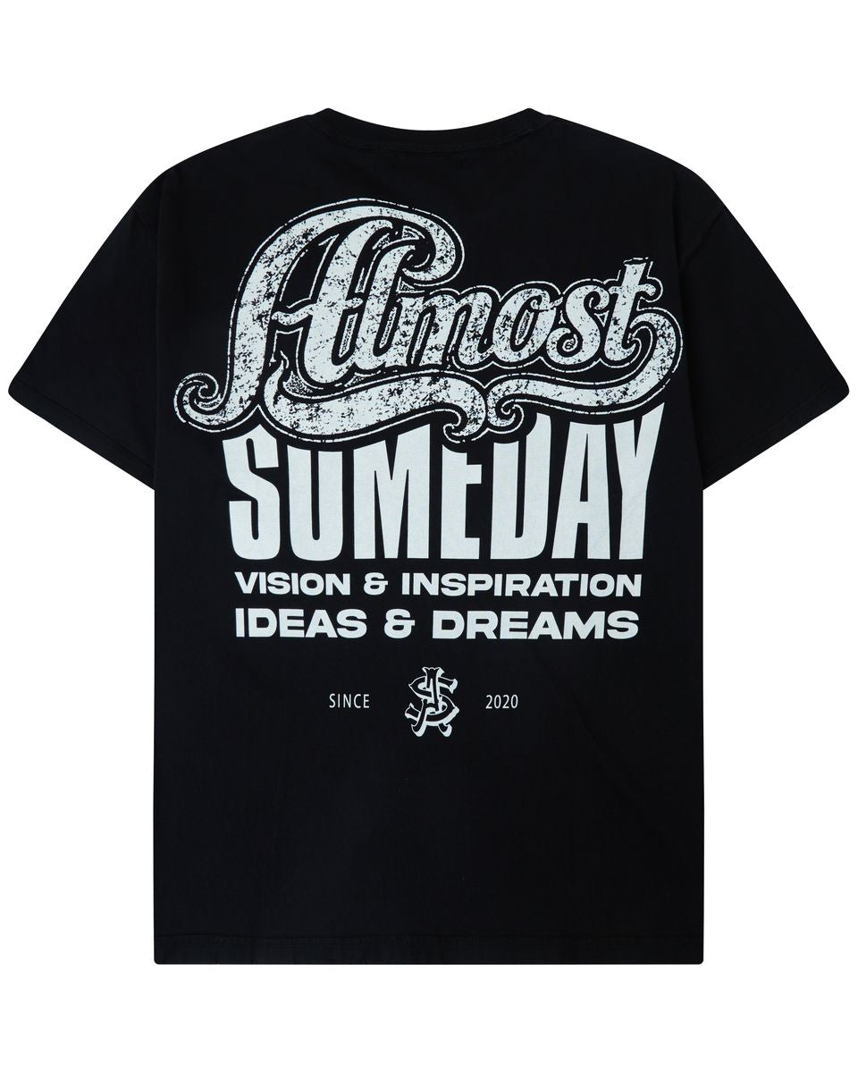 A black short-sleeve t-shirt shown from the back, featuring a large white graphic print that reads 'Almost Someday' with 'VISION & INSPIRATION IDEAS & DREAMS' underneath.