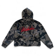 A cropped zip-up hoodie with a dark gray and black abstract collage print, featuring a large red 'Unbroken' script logo with rhinestone detailing on the back, shown against a plain white background.