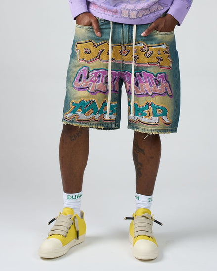 Person wearing colorful shorts with graffiti-style text and yellow sneakers on a white background