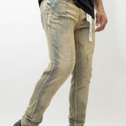 Person wearing distressed beige jeans with a white background