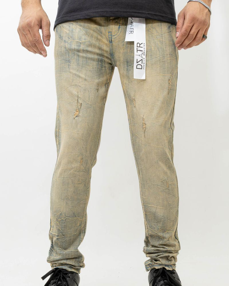 Person wearing distressed light-colored jeans with a visible brand tag on a white background