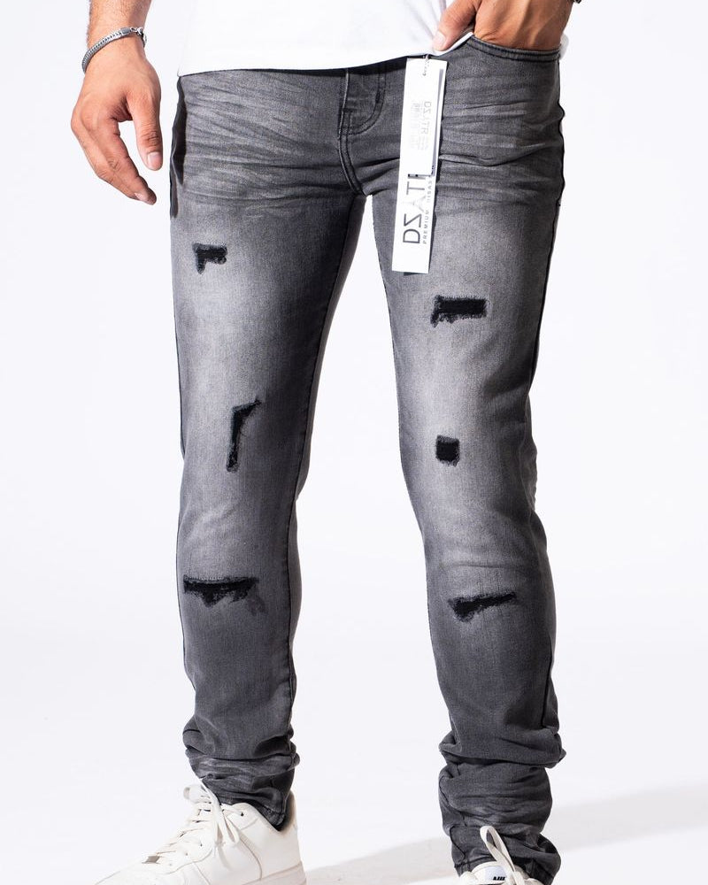 A person wearing slim-fit gray distressed jeans with ripped details and white sneakers, shown from the waist down against a plain white background.
