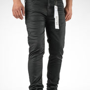 Person wearing black jeans with a visible brand tag on a white background