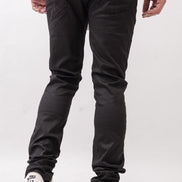 Person wearing black pants and white sneakers on a plain background
