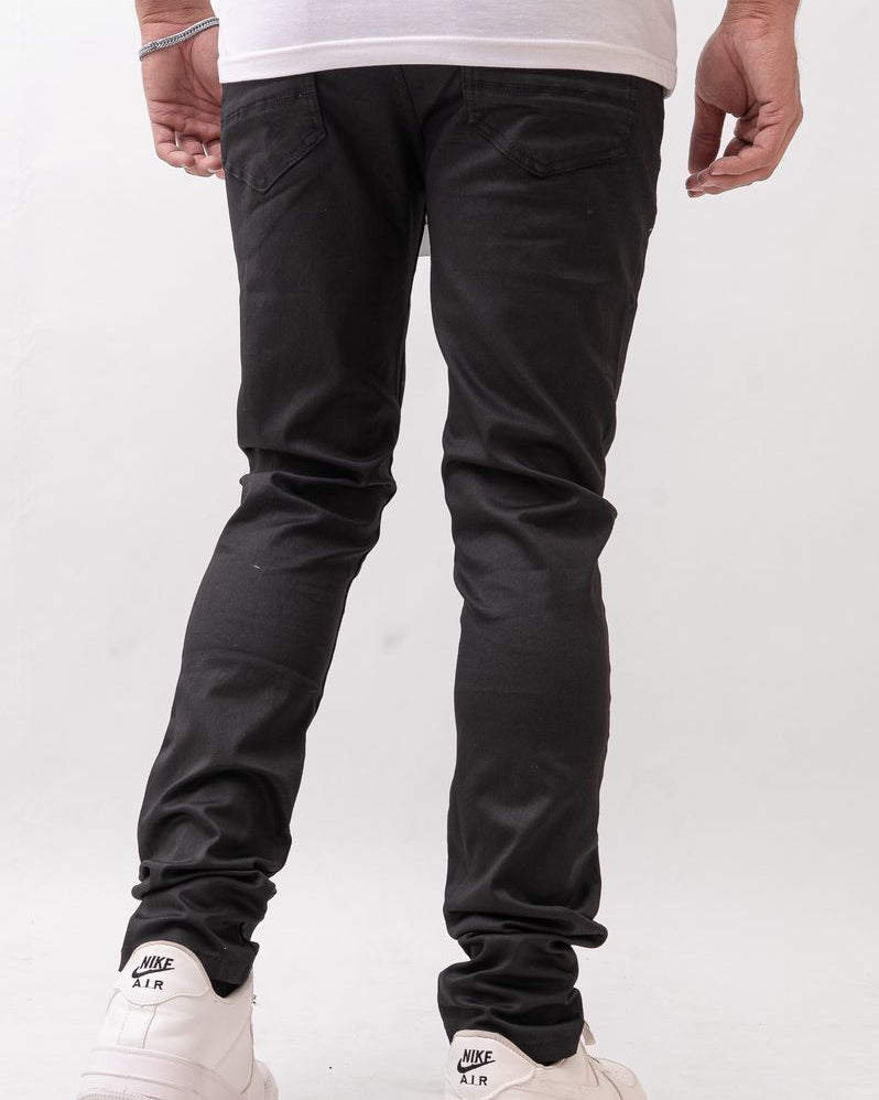 Person wearing black pants and white sneakers on a plain background