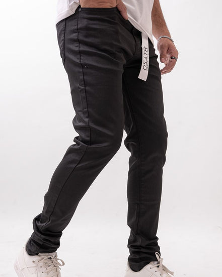 Person wearing black pants with a visible brand label on a white background