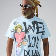 Person wearing a light blue t-shirt with graphic designs and text, standing against a plain background.