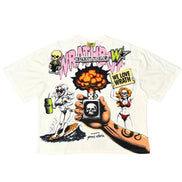 A white short-sleeve graphic t-shirt featuring a detailed illustration from the movie 'Wrestle Man 2'. The graphic includes the text 'WRESTLE MAN 2' in pink and green, a skeleton drinking from a green can, a pin-up girl holding a sign that says 'WE LOVE WRESTLE', and a hand holding a small TV with a skull on the screen.