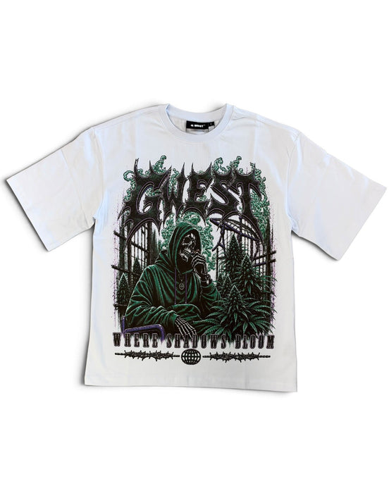 A white short-sleeve graphic t-shirt featuring a dark green and black print of a hooded figure in front of a piano, with the word 'G WEST' in a stylized font above.