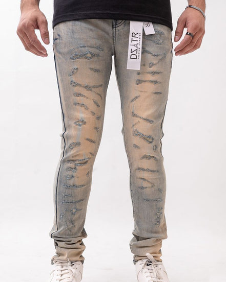 Person wearing distressed light blue jeans with a brand label on a white background