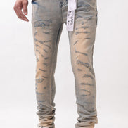 Person wearing distressed light blue jeans with a white background