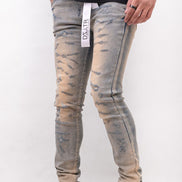 Person wearing distressed light blue jeans with a white background