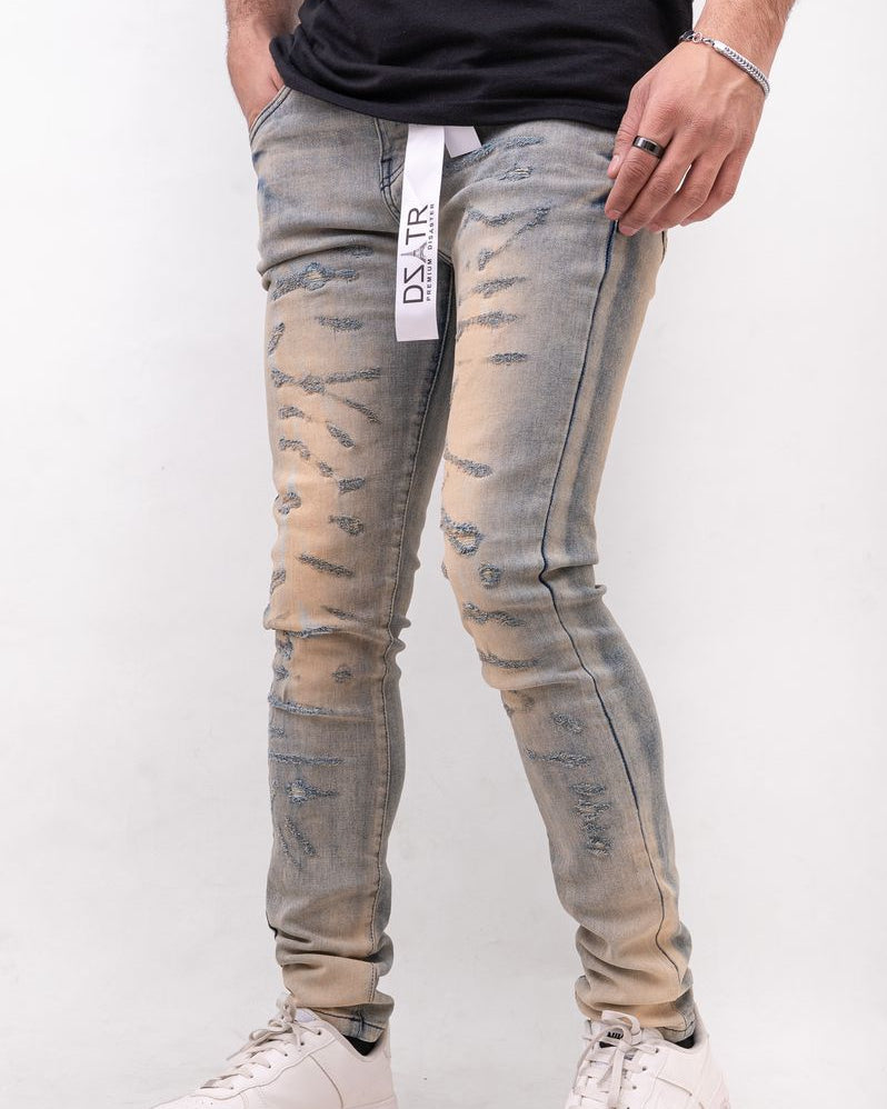 Person wearing distressed light blue jeans with a white background