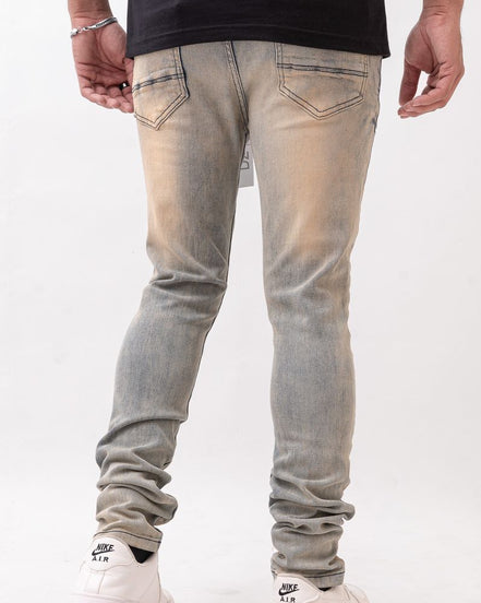 Person wearing light gray jeans and white sneakers on a white background