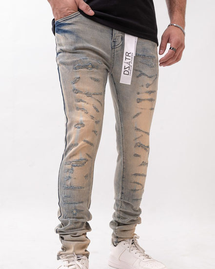 Person wearing distressed gray jeans with a visible brand label on a white background