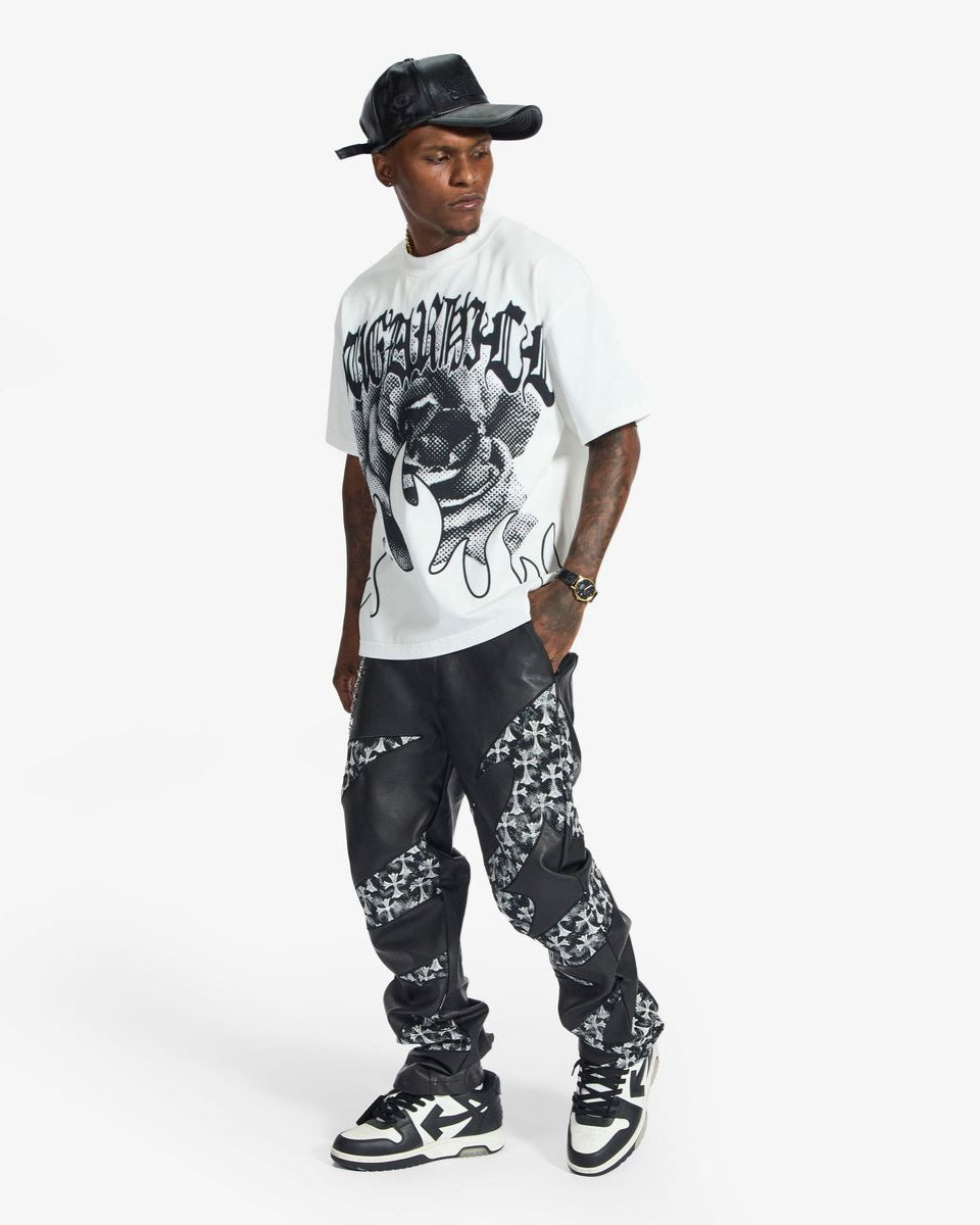 Man wearing a white t-shirt with graphic design and a black cap on a white background