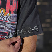 Close-up of a person wearing a black graphic t-shirt with colorful text and images.