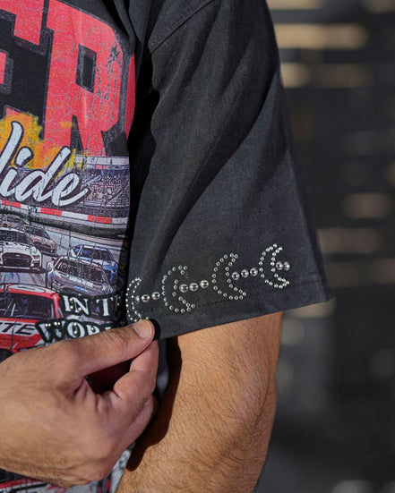 Close-up of a person wearing a black graphic t-shirt with colorful text and images.