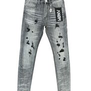 Distressed gray denim jeans with black ripped details, featuring a black hangtag with 'ANOM' on the pocket and a black inner waistband.