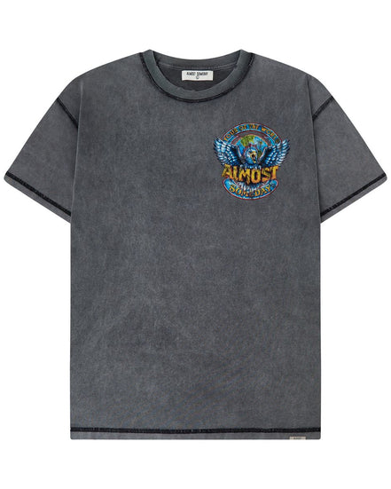 A dark gray mineral-wash short-sleeve t-shirt with a colorful graphic on the left chest featuring a winged globe and the text 'TOUR OF THE WORLD ALMOST SOMEDAY'.