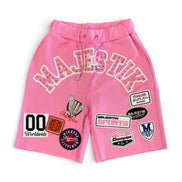 Pink shorts with various patches on a white background
