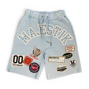 Light blue shorts with various patches on a white background