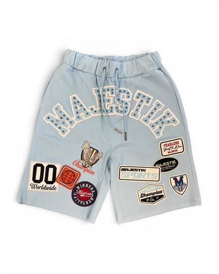 Light blue shorts with various patches on a white background