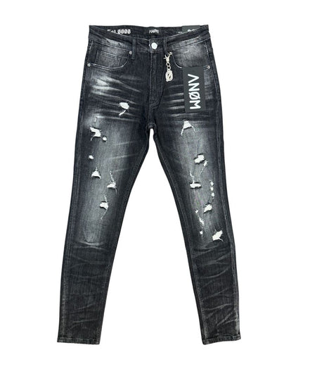 Distressed black denim jeans with white 'ANOM' lettering on the right thigh, ripped details, and a silver metal zipper pull, shown flat against a white background.