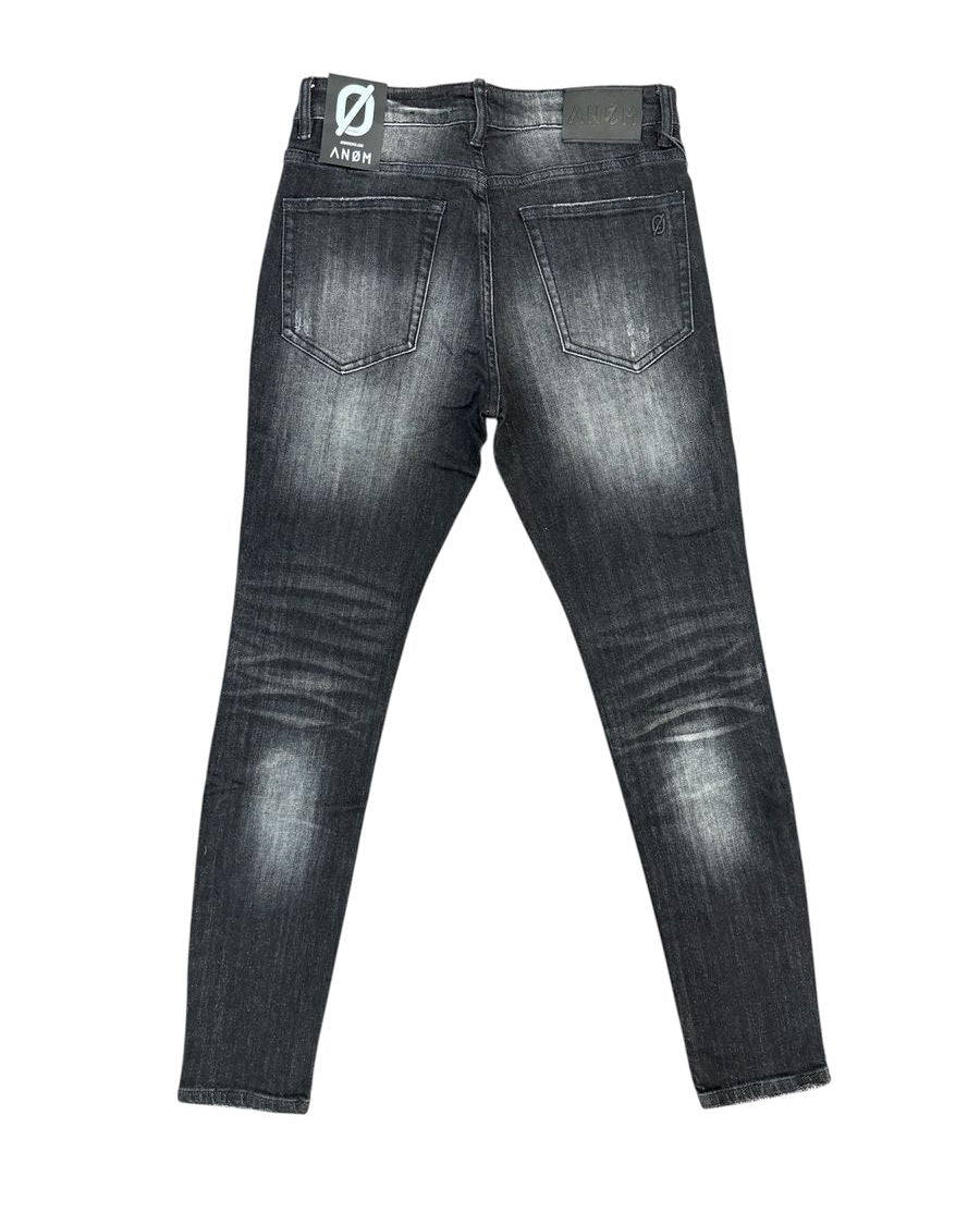 Back view of a pair of dark gray washed skinny jeans on a white background, featuring a visible 'ANOM' brand patch on the back waistband.