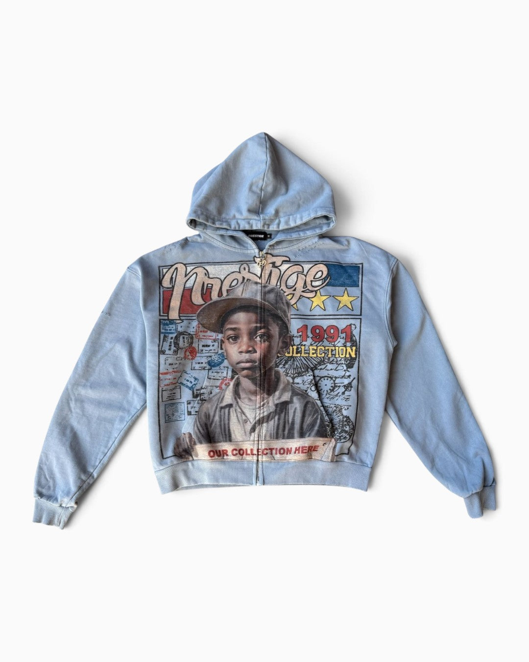 A light blue zip-up hoodie featuring a large graphic print on the front with a portrait of a young boy and text including 'Majestic' and '1991 Collection', shown against a plain light background.