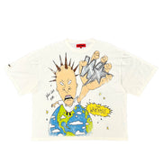 A white short-sleeve graphic t-shirt featuring a cartoon illustration of a spiky-haired character holding a star above a blue and green globe, with a yellow 'WHAT?' speech bubble.