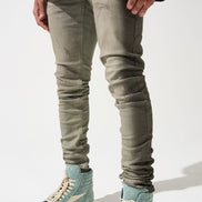 Person wearing light green high-top sneakers and slim-fit jeans on a white background
