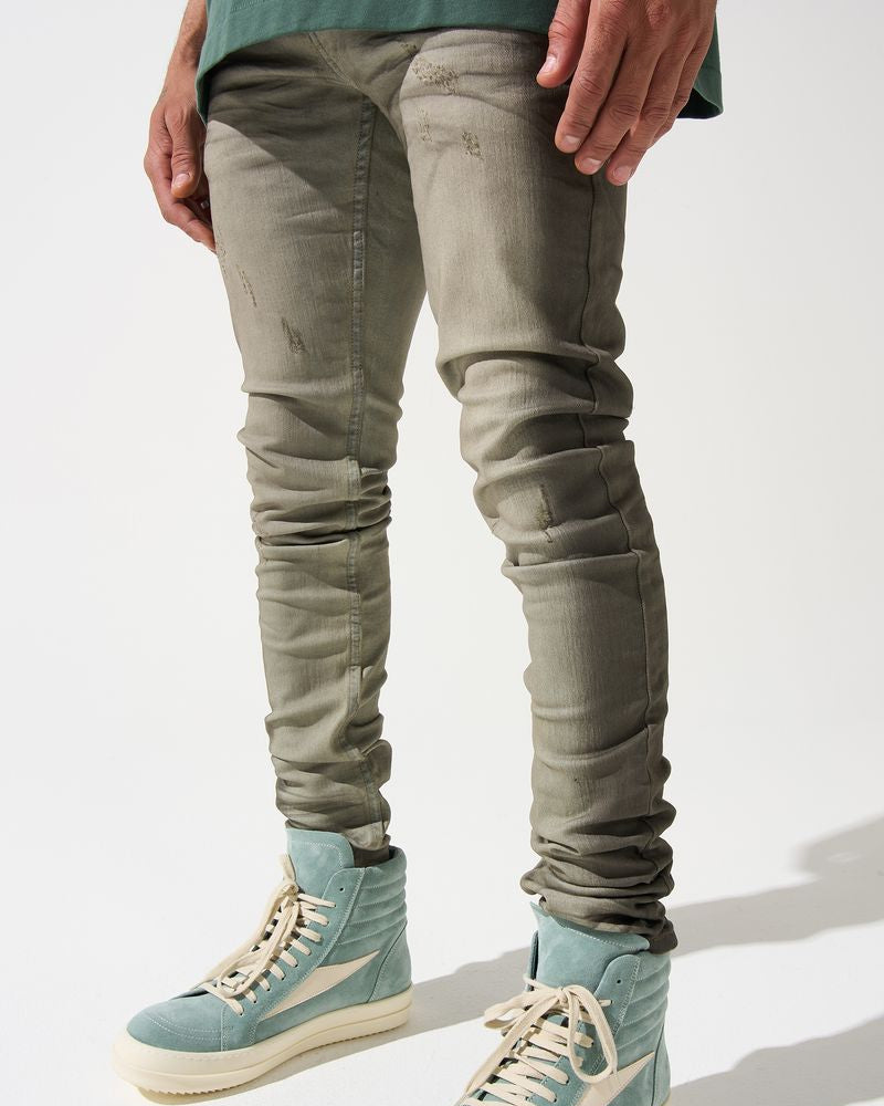 Person wearing light green high-top sneakers and slim-fit jeans on a white background