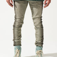 Person wearing green shirt, gray pants, and light blue sneakers on a white background