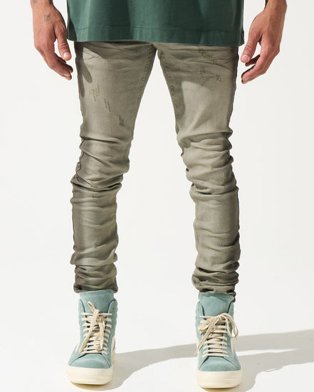 Person wearing green shirt, gray pants, and light blue sneakers on a white background